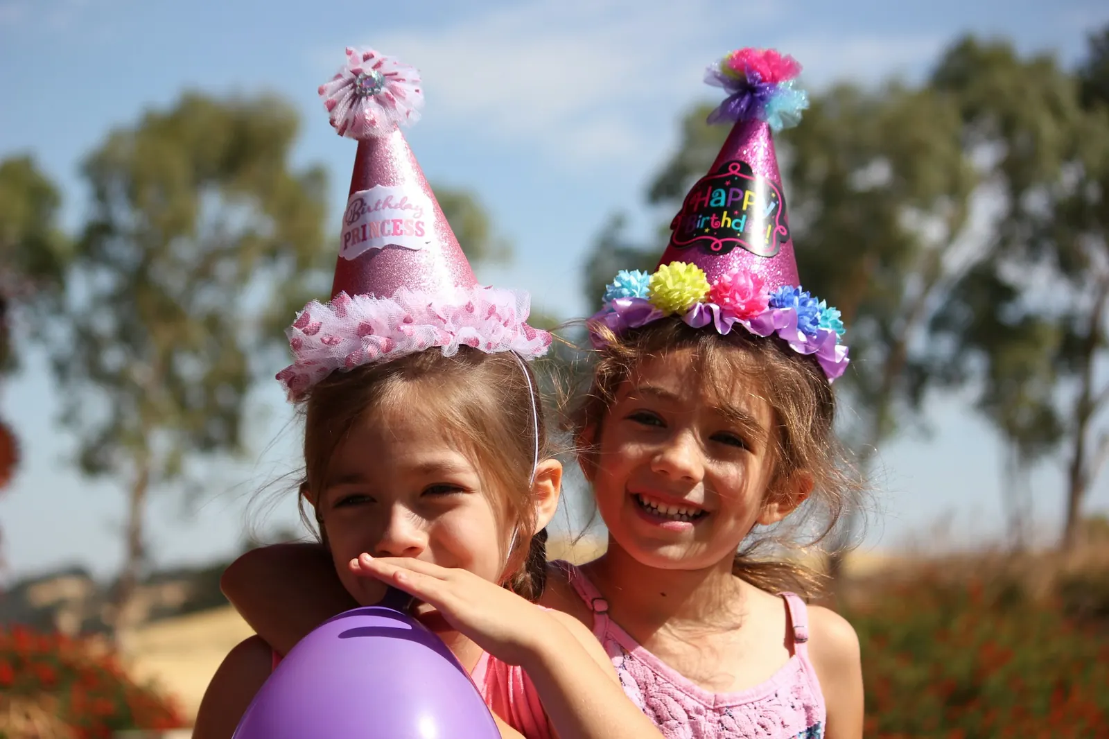 Two children in party hats at a birthday party